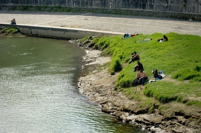 People on grass by river