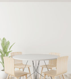 Empty chairs and table against white background