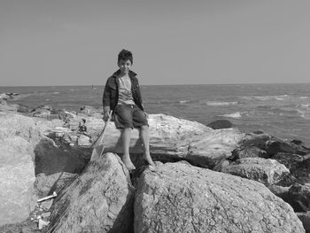 Rear view of man standing on beach against clear sky