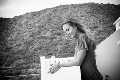 Side view of woman standing against mountain