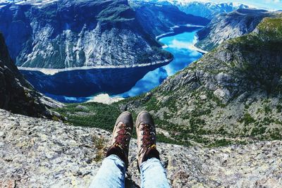 Low section of woman relaxing on cliff