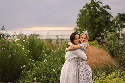 A young mother with a teenage daughter spends time in the garden. family holiday and togetherness.