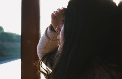 Close-up of girl shielding eyes while looking away