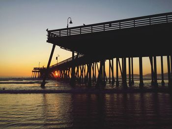 Silhouette pier on sea against sky during sunset