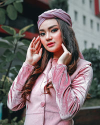 Young woman looking away while standing outdoors