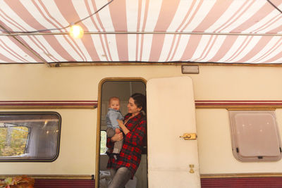 Mother with son standing in motor home