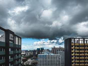 Buildings in city against cloudy sky