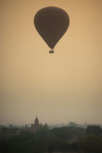 Hot air balloon flying in sky at sunset