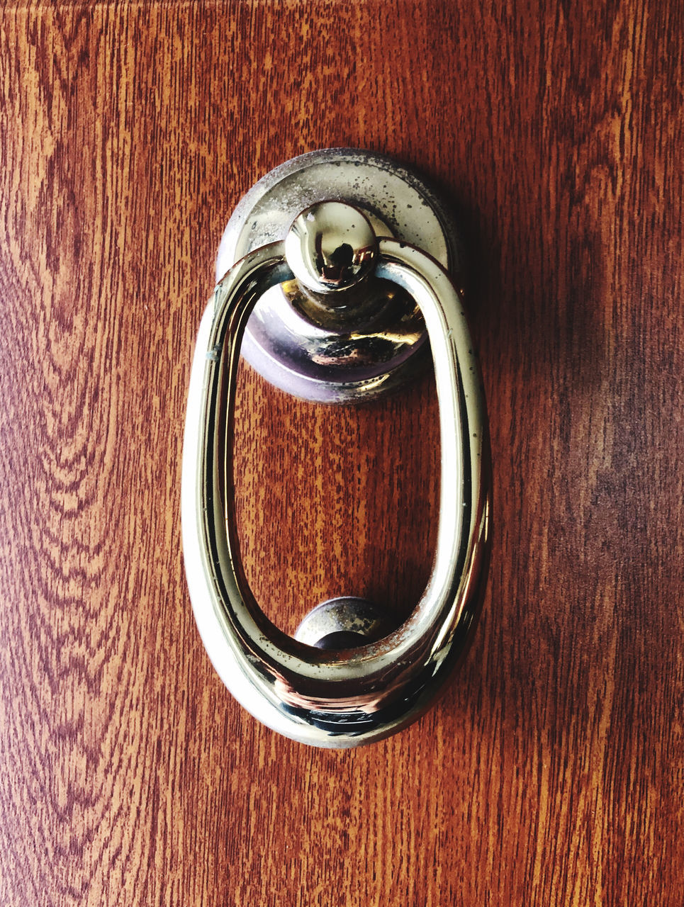 CLOSE-UP OF DOOR KNOCKER ON WOODEN ENTRANCE