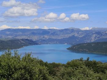 Scenic view of sea and mountains against sky