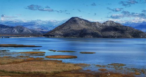 Scenic view of lake and mountains against sky