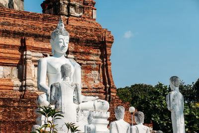 Statue against temple building against sky