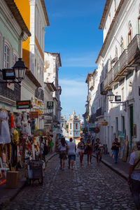 People walking on street amidst buildings in city