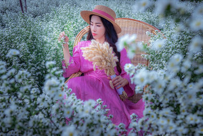 Young woman with pink flowers in park