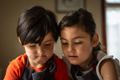 Portrait of two girls with dark hairs busy baking