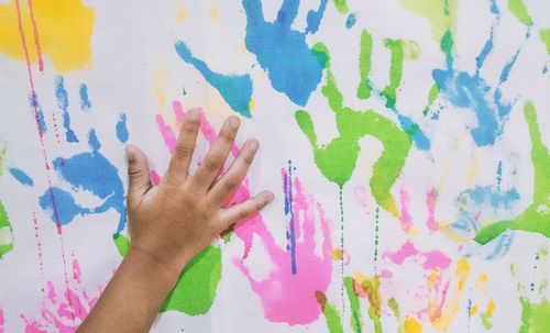 Close-up of hand holding multi colored umbrella