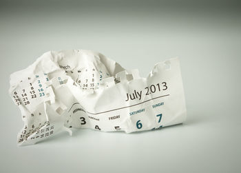 High angle view of crumpled calendar on white background