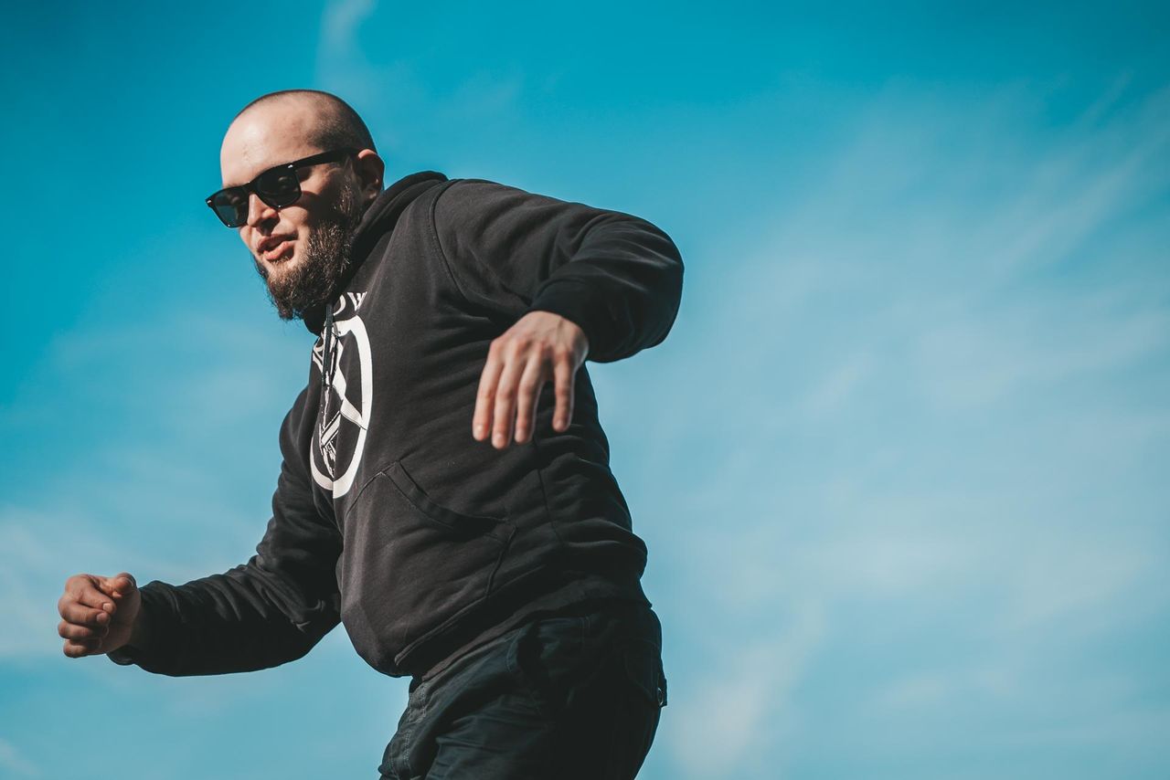 one person, men, adult, blue, sports, sky, copy space, clothing, athlete, lifestyles, glasses, vitality, nature, strength, exercising, waist up, motion, sports training, low angle view, player, cloud, emotion, young adult