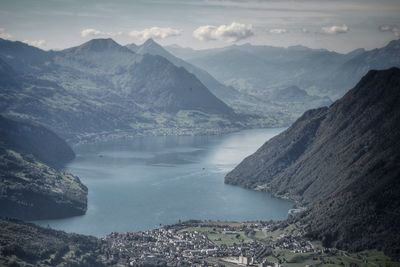 Scenic view of river by mountains against sky