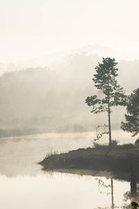 Scenic view of lake against sky during foggy weather