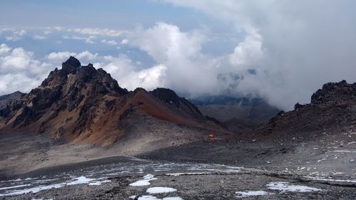 Scenic view of mountains against cloudy sky