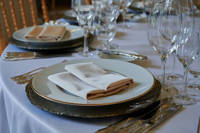 Plate with crockery and cutlery on table in restaurant