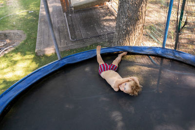High angle view of boy lying on trampoline