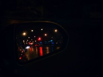 Reflection of illuminated lights on glass window at night