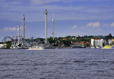 Boats in sea against cityscape and sky