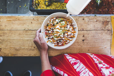 Midsection of female customer with fresh tex-mex in bowl at food truck