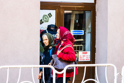 Woman standing by railing in winter