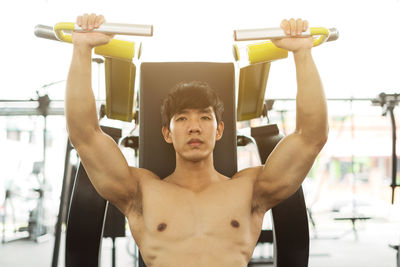 Shirtless man exercising at gym