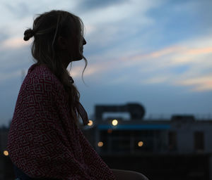 Side view of woman against sky at sunset