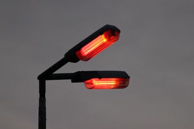 Close-up of illuminated street lamp against sky