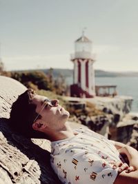 Side view of man leaning on wall