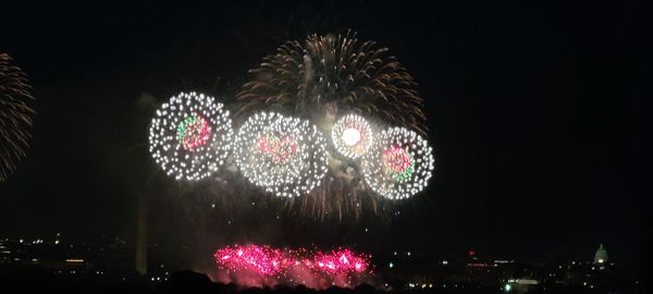 Low angle view of firework display at night