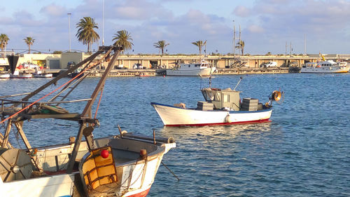 Boats moored in sea against sky