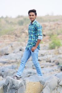 Portrait of young man standing on rock