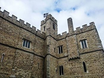 Low angle view of building against cloudy sky