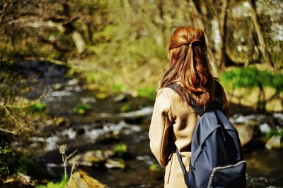 Rear view of woman standing against trees