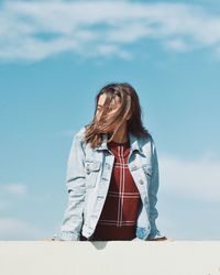 Woman looking away against sky