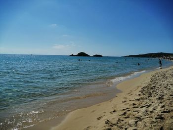 Scenic view of beach against clear blue sky