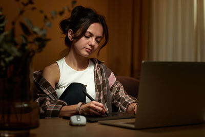 Young woman using laptop at table