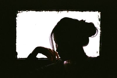 Portrait of young man sitting in window