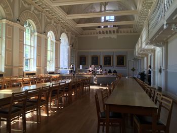 Empty chairs and tables in illuminated building