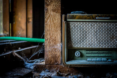 Close-up of old radio in abandoned shelf