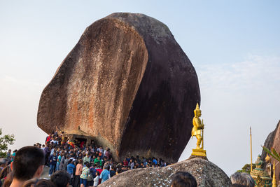 Group of people on rock against sky