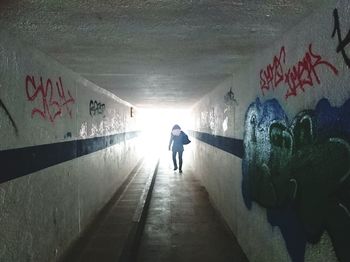 Full length of woman walking in tunnel