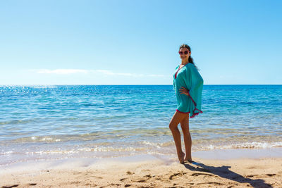 Full length of man standing on beach against sky