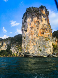 Rock formation by sea against sky